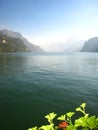 Wonderfully panorama with an emerald blue swiss lake with snow-covered mountains and flowers