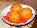 Christmas oranges with cloves on a plate Royalty Free Stock Photo