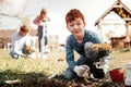 Wondering boy with freckles surprising because planting first time by himself Royalty Free Stock Photo