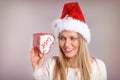 Wondering Christmas woman with a Santa hat holding a gift box Royalty Free Stock Photo