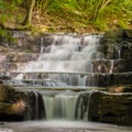 Wonderous waterfall in rocks in a fall forest