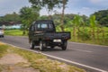 Black Suzuki carry pickup truck on the road