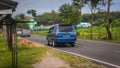 Blue Isuzu panther family car driving on the road