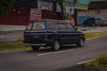 Dark blue Isuzu panther family car driving fast on the road in the afternoon