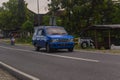 Blue Isuzu panther family car driving on the road