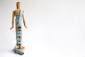 Wood mannequin holding and wrapped in a blue tape measure for a weight loss and plastic surgery beauty concept