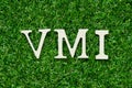 Wood letter in word VMI abbreviation of vendor managed inventory on gree grass background