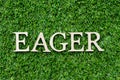 Wood letter in word eager on green grass background