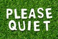 Wood letter in word please quiet on green grass background Royalty Free Stock Photo