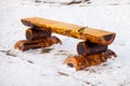 Wood bench on snow background. Beautiful wooden bench made of logs. Winter