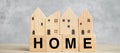 Wood block with HOME text and house model on wooden background. Banking, real estate, Property investment, home mortgage, Royalty Free Stock Photo