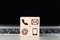 Wood block symbol telephone, mail, address and mobile phone on laptop keyboard Royalty Free Stock Photo