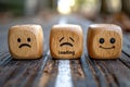 Wood blocks with happy, sad and loading expression on textured surface in daylight