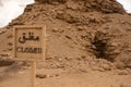 Wood board sign in front of one of the pyramids at the Saqqara site, in both english in arabic stating Closed