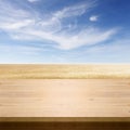 Wood board table in front of field of wheat on summer background. Ready for product display montages