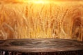 Wood board table in front of field of wheat on sunset light. Ready for product display montage
