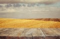 Wood board table in front of field of wheat on sunset light. Ready for product display montages