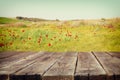 Wood board table in front of summer landscape of field with many flowers . background is blurred Royalty Free Stock Photo