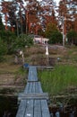 Wood boardwalk leading up from lake towards cabin