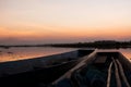 Wood boat moored on the river with the sunset.