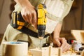 Wood boring drill in hand drilling hole in wooden bar