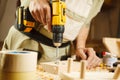 Wood boring drill in hand drilling hole in wooden bar