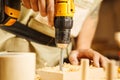 Wood boring drill in hand drilling hole in wooden bar