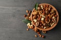 Wood bowl with different tasty nuts on gray wooden background Royalty Free Stock Photo