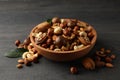 Wood bowl with different tasty nuts on gray wooden background Royalty Free Stock Photo