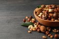 Wood bowl with different tasty nuts on gray wooden background Royalty Free Stock Photo