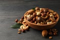 Wood bowl with different tasty nuts on gray wooden background Royalty Free Stock Photo