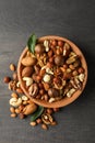 Wood bowl with different tasty nuts on gray wooden background Royalty Free Stock Photo