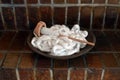 Wood bowl filled with white cotton roving and a spindle on a brick background