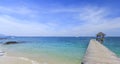 Wood bridge pier on summer tropical sea in blue sky.