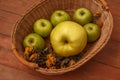 Wood brown background with a basket of green apples Royalty Free Stock Photo