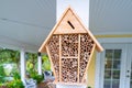 Wood bug hotel in a home garden for gardening hobby. Insect hotel for bees with crevices to hibernate or lay eggs some plugged.