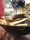 Wood burning in the campfire bowl to prepare the coals for grill