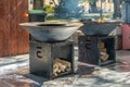 Wood-burning grill with a metal plate for frying meat and vegetables with a flame of fire.