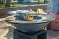 Wood-burning grill with a metal plate for frying meat and vegetables with a flame of fire.