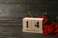 Wood calendar with 14 february and roses on wooden background Royalty Free Stock Photo