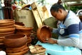 Wood carver puts finishing touches on wooden plates sold at Dapitan Arcade in Manila, Philippines