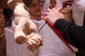 Wood carver's hands sculpting a wooden angel