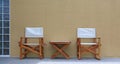 Wood chairs and table situated outside the cafe against the cement wall Royalty Free Stock Photo