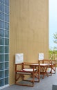 Wood chairs and table situated outside the cafe against the cement wall. Side view Royalty Free Stock Photo