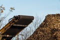 Wood chips dumped in a pile by a large industrial wood chipper..