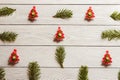 Wood christmas background with fir branches and fir tree shaped pins, top view.