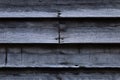 Wood clapboard siding on an old historic cabin showing defacing scratched graffiti