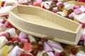 Wood coffin on top of pile of assorted sweets, junk food and candy concept for death caused by diabetes and metabolic disease,