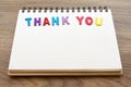 Wood colorful letter word THANK YOU lay down notebook on wood ba