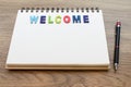 Wood colorful letter word WELCOME lay down notebook on wood back